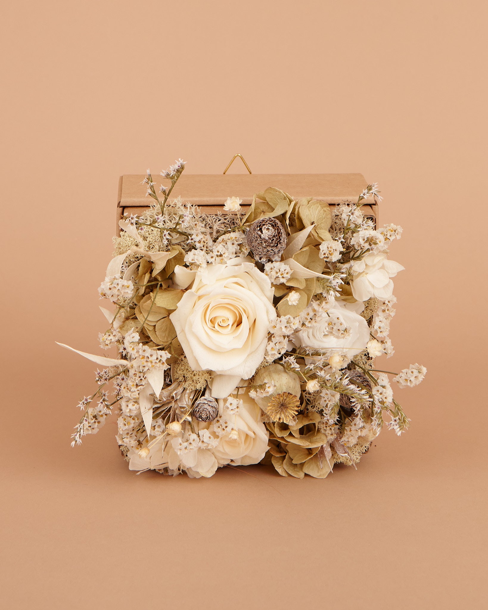 Vista frontale di Quadro Fiorito con rose di color bianco champagne e fiori stabilizzati e secchi